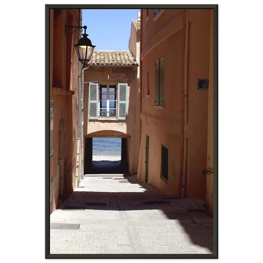 Photo d'art d'une ruelle ombragée à Saint-Tropez menant vers la mer Méditerranée avec architecture provençale